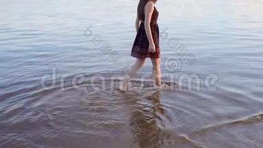 日落时，这位黑发女郎沿着沙滩散步。